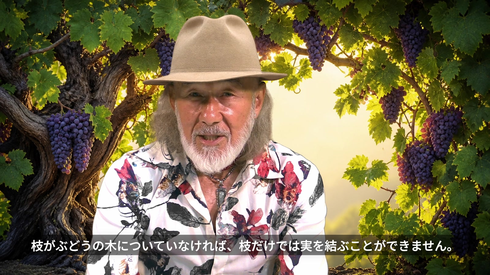 ぶどうの木を背景に「枝がぶどうの木についていなければ、枝だけでは実を結ぶことができません」と語るアーサー・ホーランド