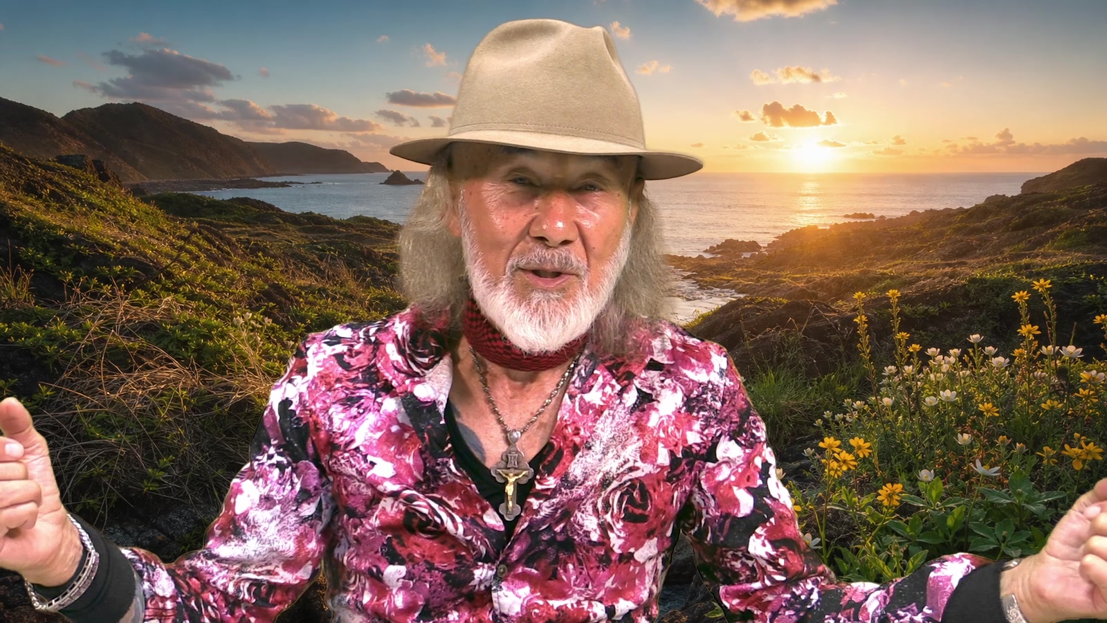 夕日の海を背景に、両腕を広げて呼びかけるアーサー・ホーランド