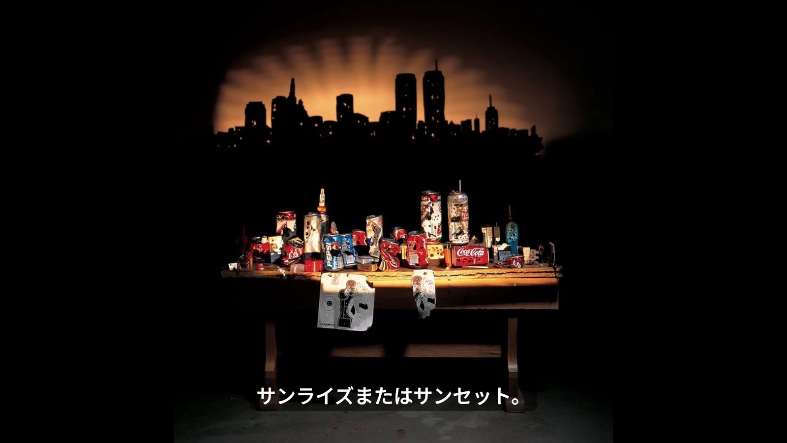 空き缶の造形と街並みのような影を紹介する映像中の作品。