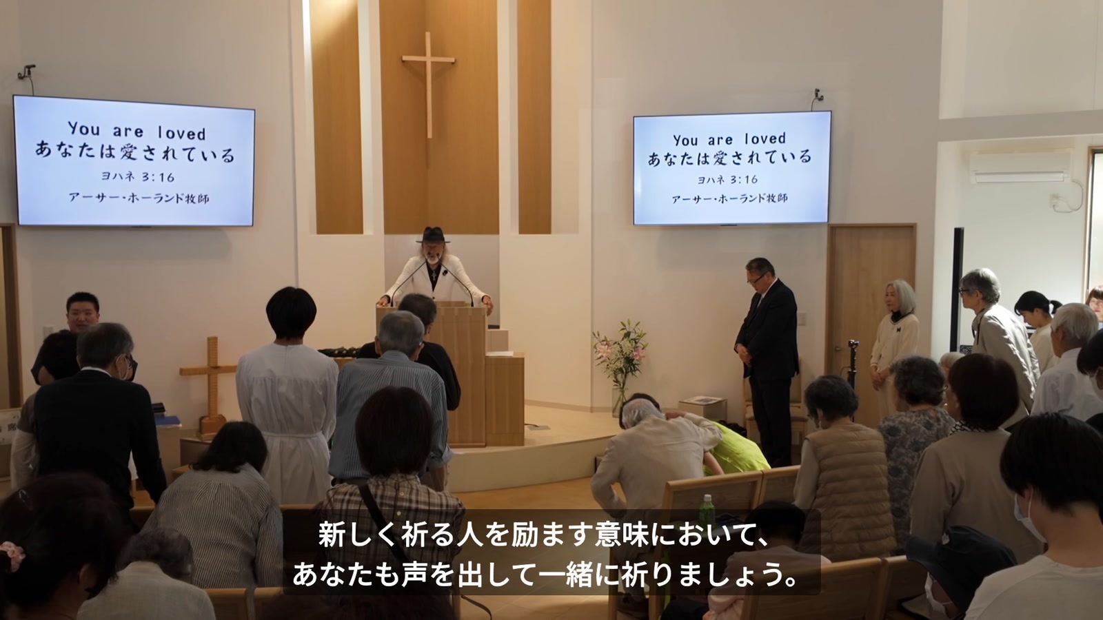 立ち上がった会衆と共に祈る北本福音キリスト教会の礼拝
