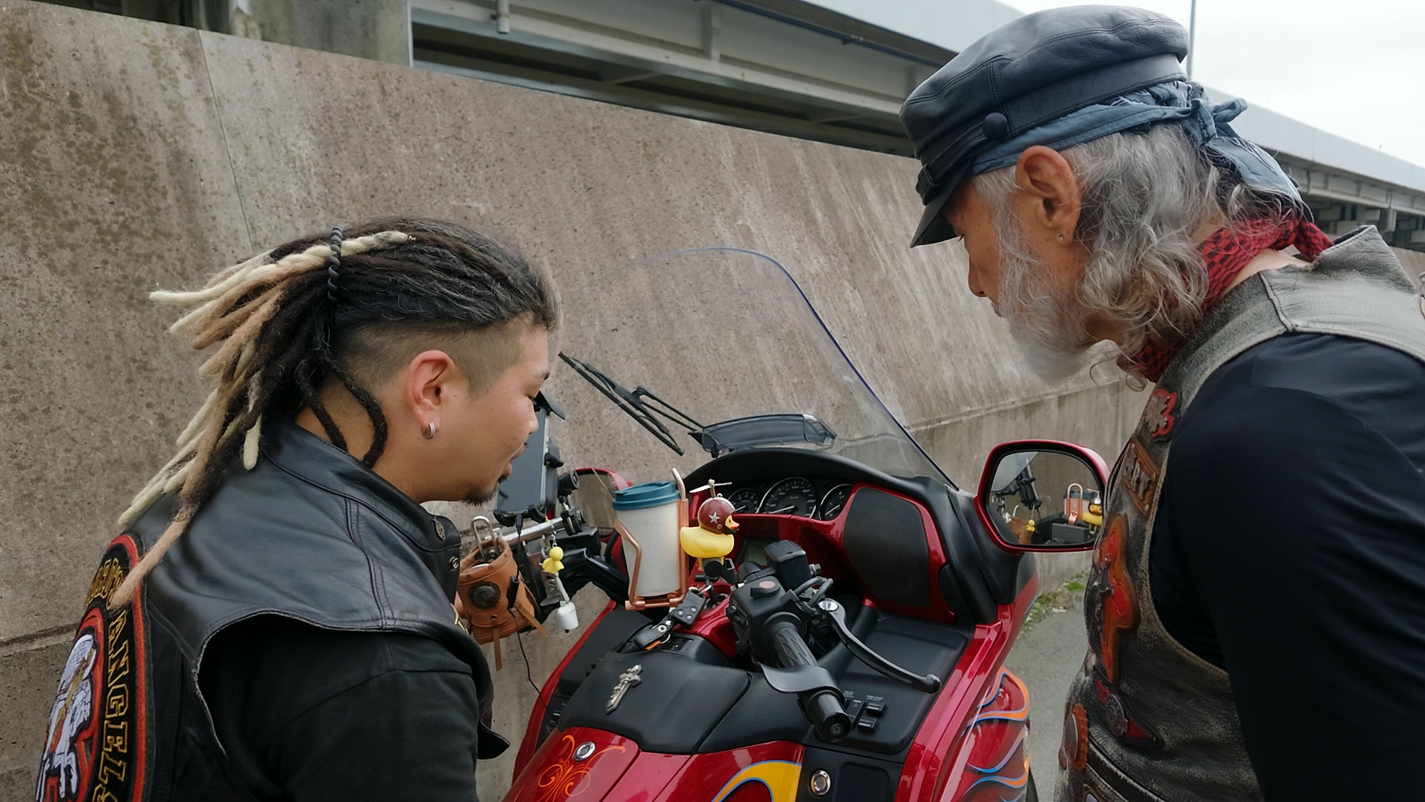 ファイアーペイントのバイクを挟んで語り合うアーサーホーランドとメンバー
