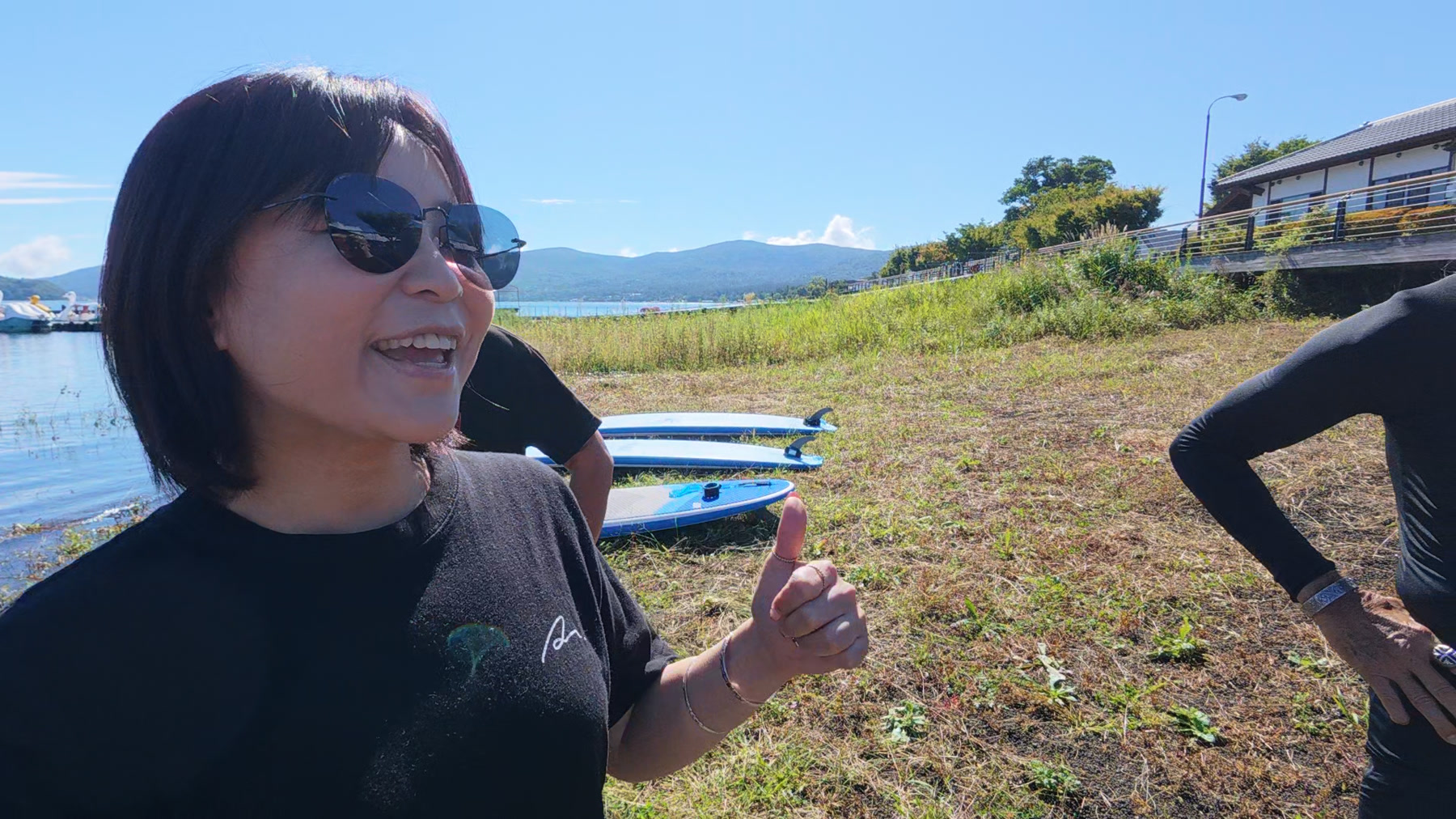 山中湖畔で笑顔を見せ、親指を立てるわかさん