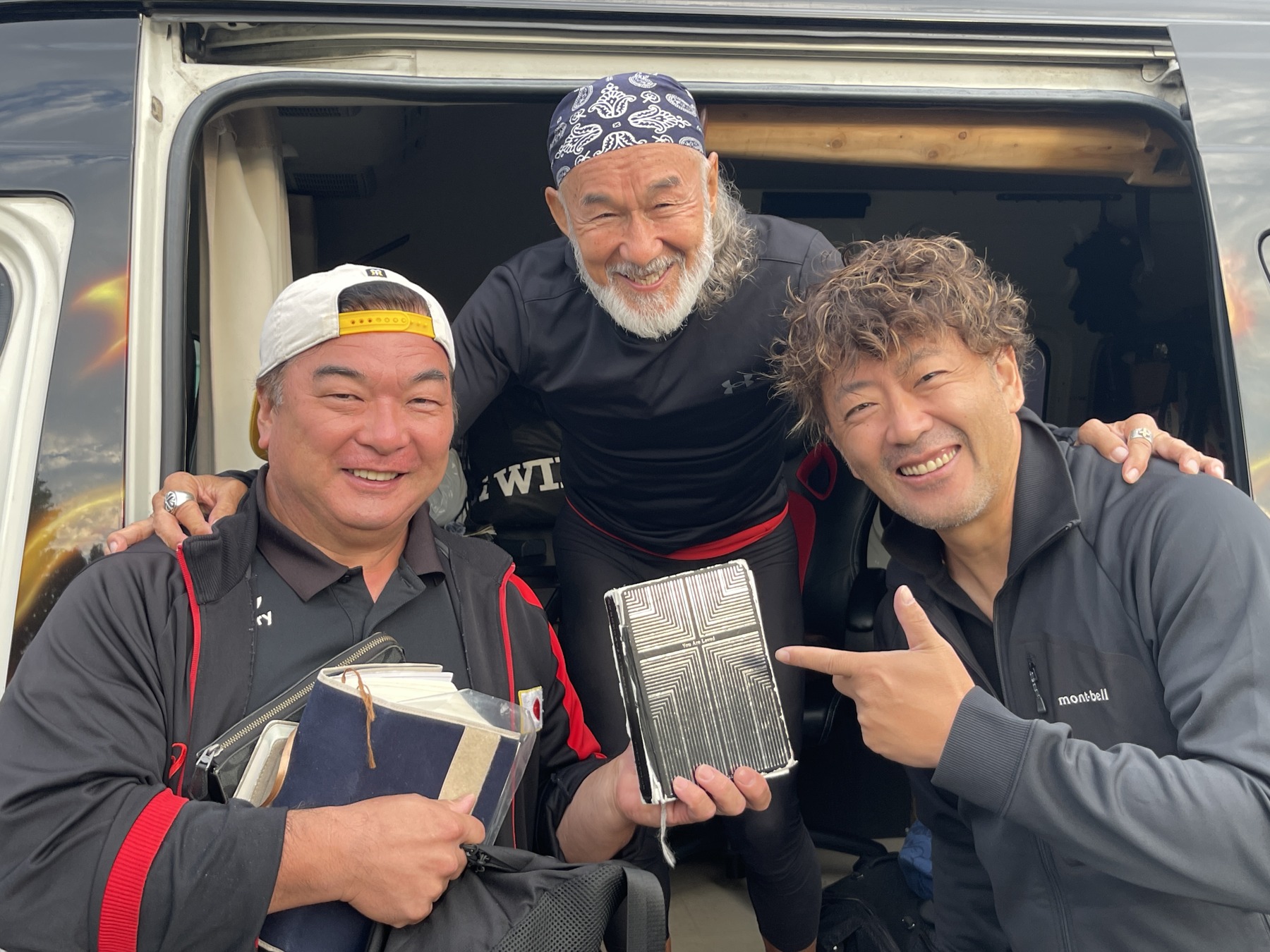 DAY02｜前日の一枚。聖書と読み込んだ『You are loved』を手に、アツシさん、アーサー先生、タナカツさん。