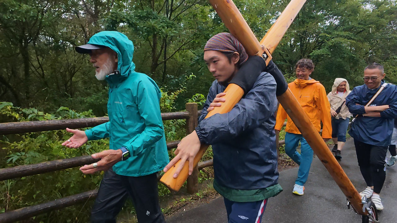 十字架を担ぎ、自分の旅と聖書との出会いを語るユウダイさん。