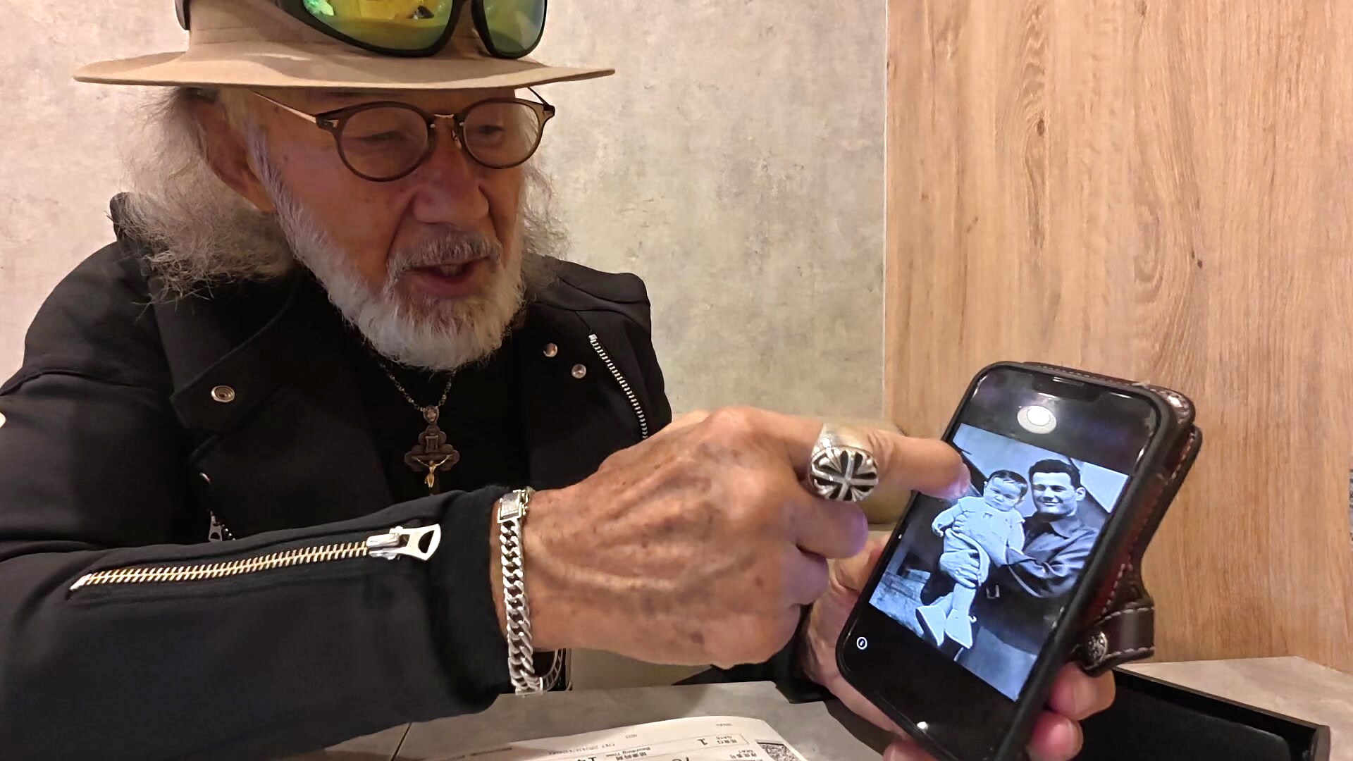父の日にお父様とのツーショット写真をスマートフォンで見せるアーサー先生