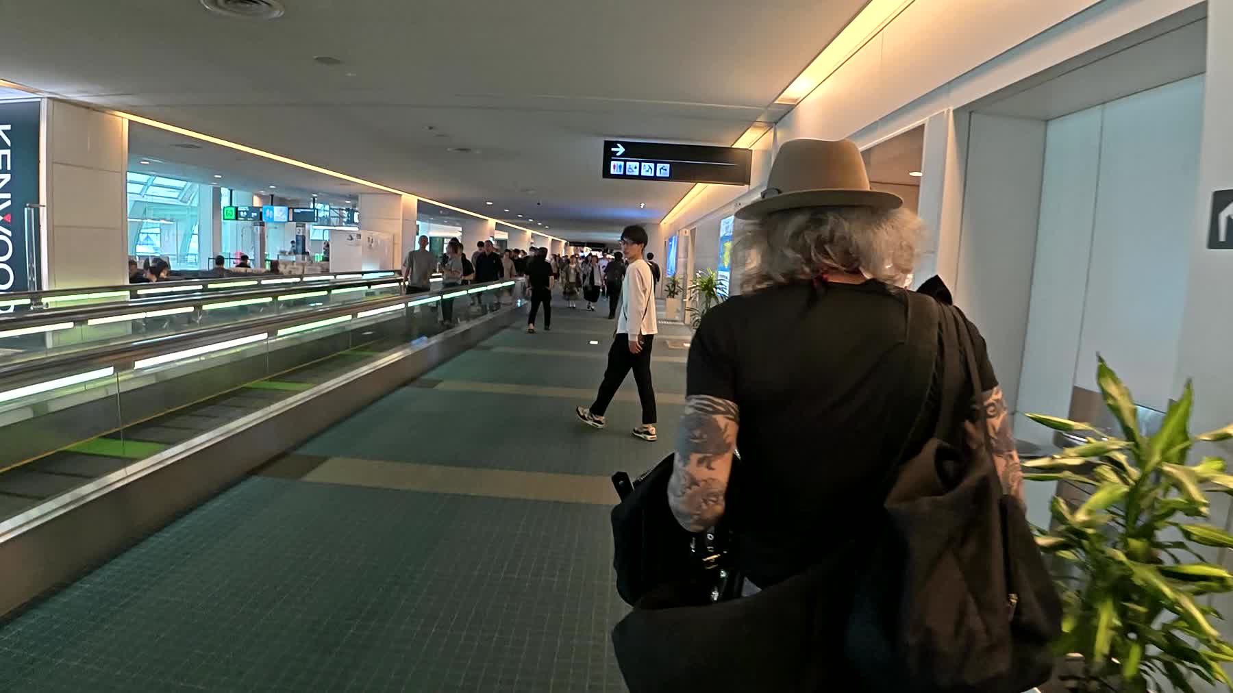 羽田空港のターミナルを歩くアーサー先生