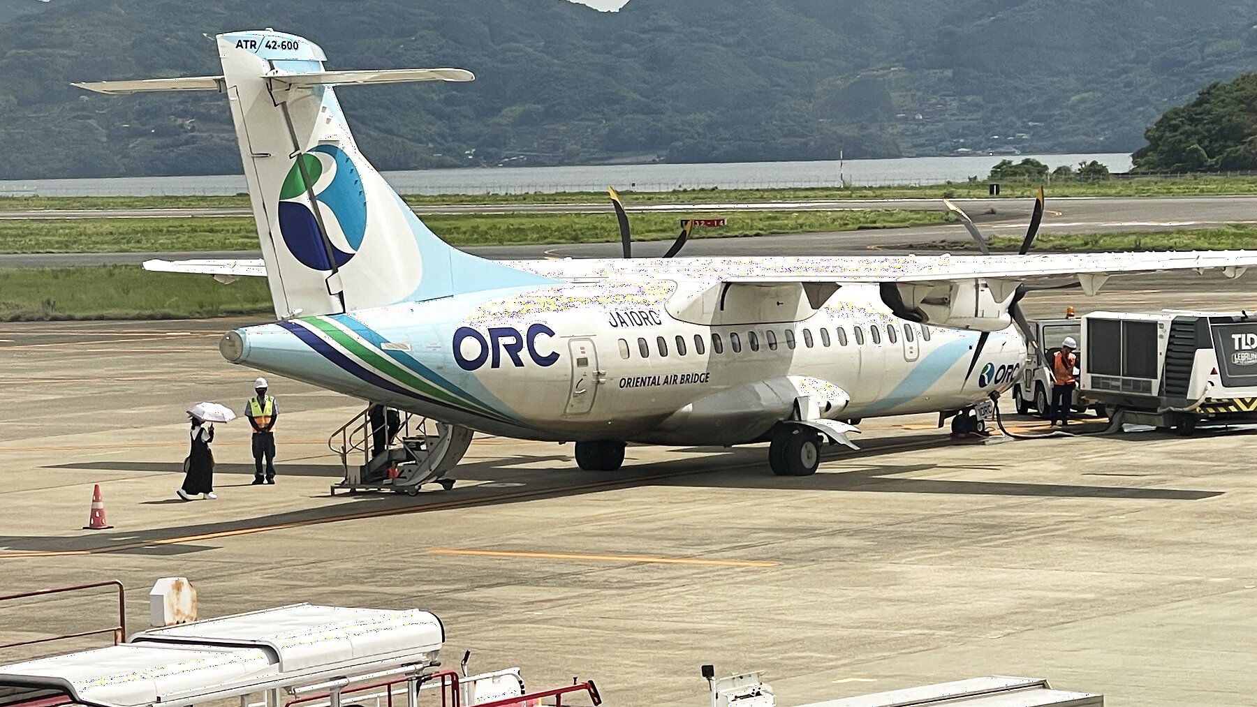 五島つばき空港の滑走路脇に停まるORCのプロペラ機
