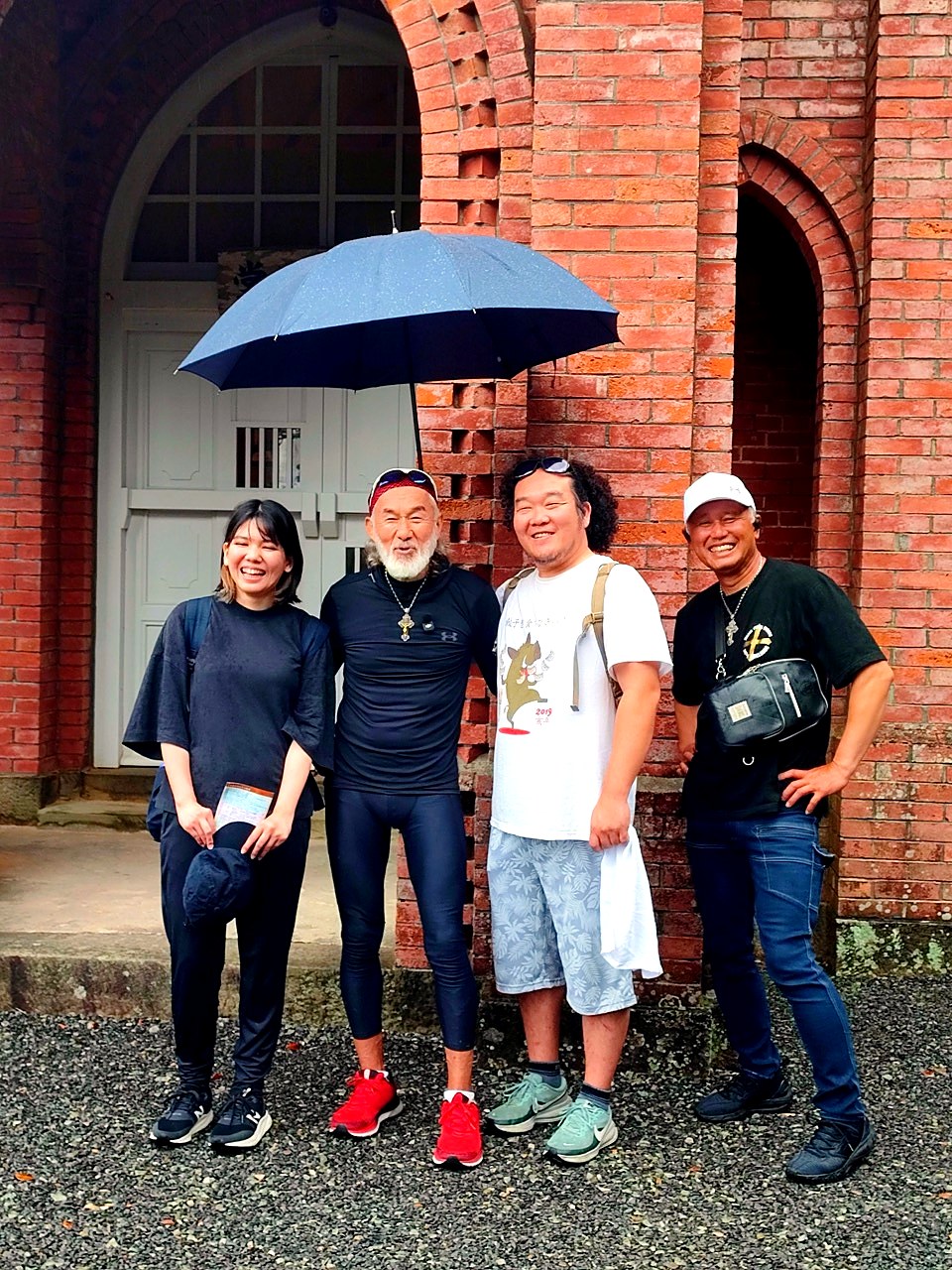 堂崎天主堂の外観前でアーサー先生と参加者が並ぶ集合写真