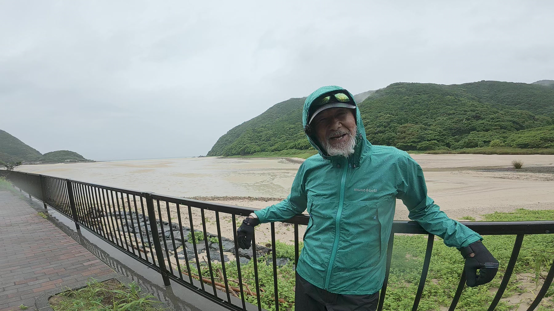 雨の道を十字架とともに進むアーサー先生と参加者