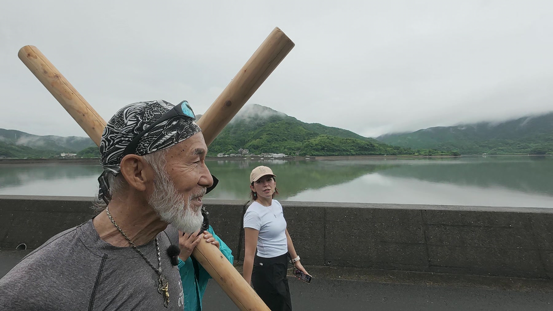 久賀島の海を背に笑顔で歩くアーサー先生