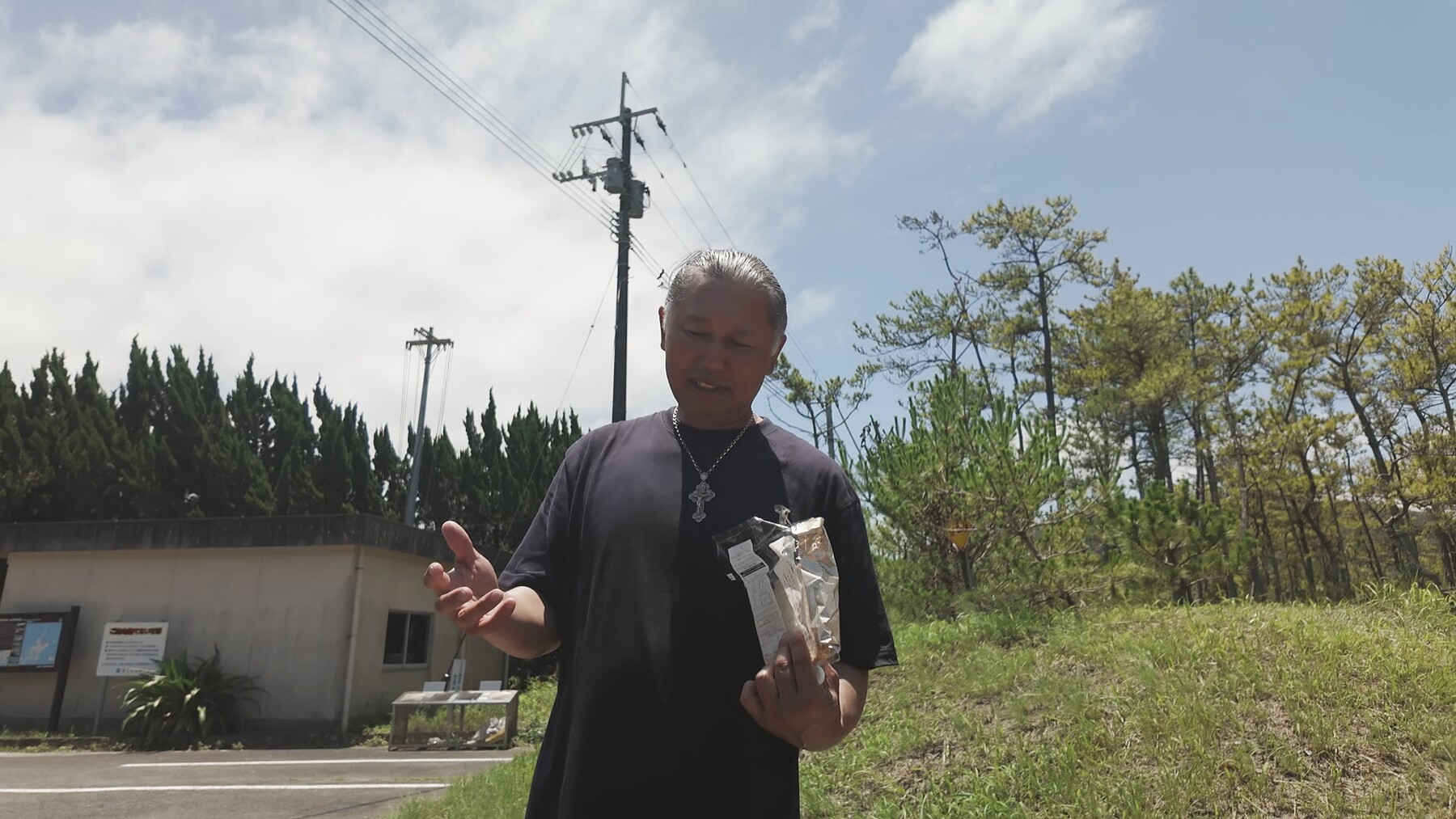 蛤浜の屋外で聖餐式のパンを手に語るアーサー先生