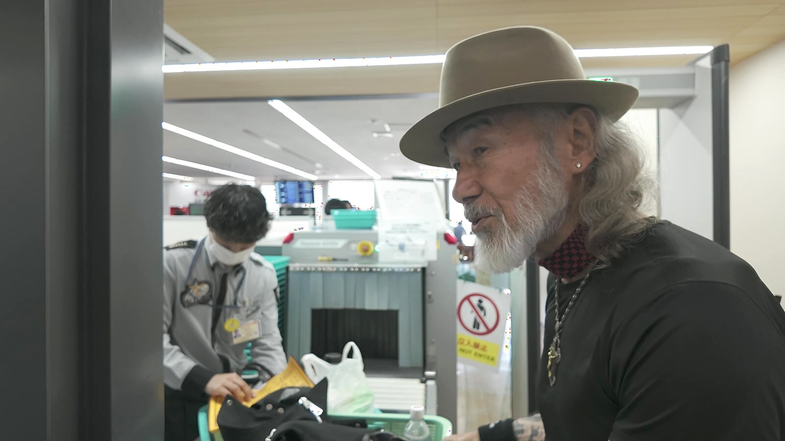 長崎空港の保安検査場で手続きを進めるアーサー先生